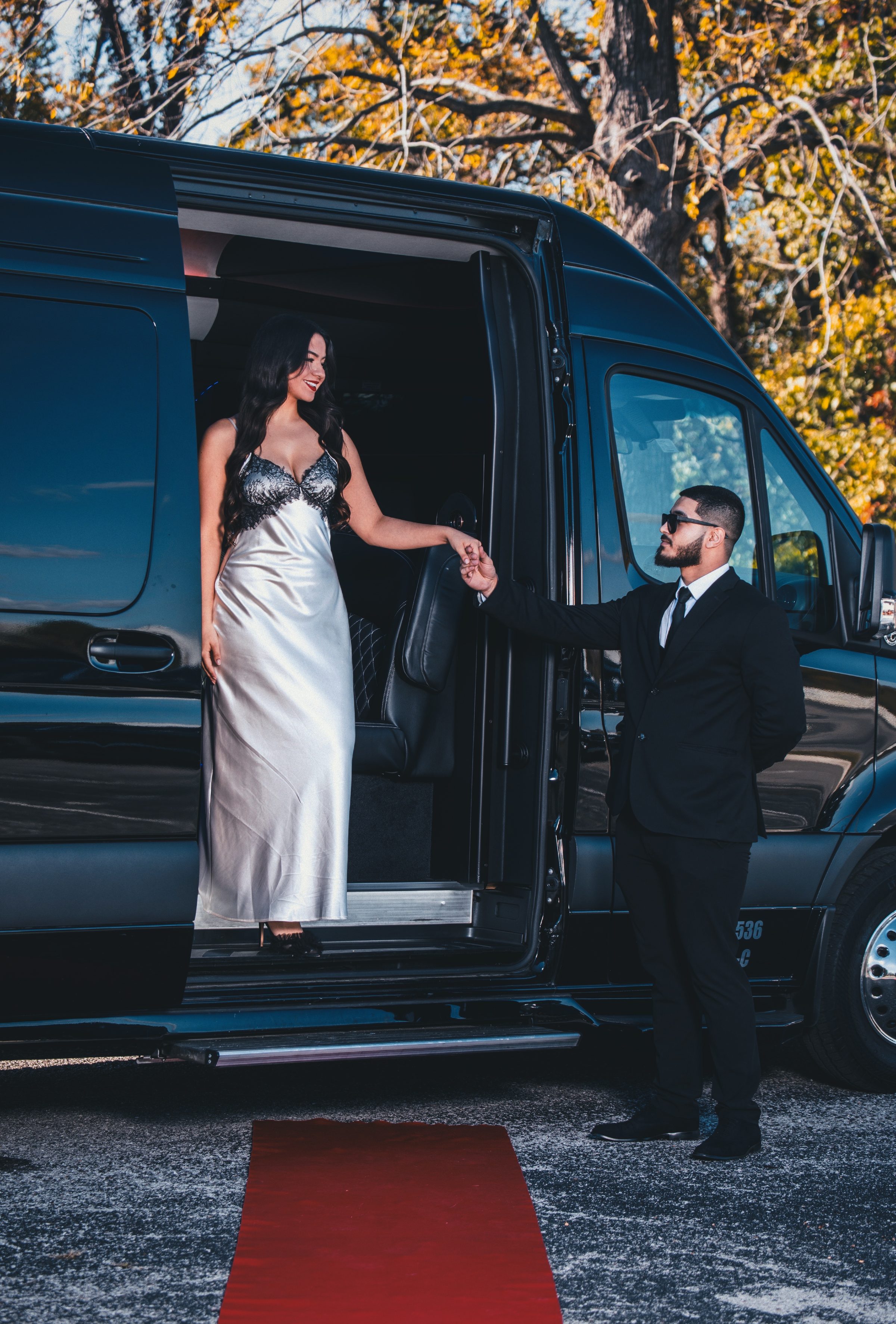 Guest stepping onto a red carpet from a Nashlux vehicle